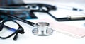 Banner. Doctor`s workplace with stethoscope, clipboard, glasses and pills. Close-up. Selective focus