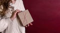 Banner. Faceless young woman in knitted white sweater holds Box gift in craft paper in hands Royalty Free Stock Photo