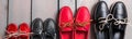 Banner with Family boat shoes on wooden background. Four pair of red and black boat shoes on grey desk with rope