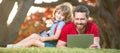 Banner of father on son school boy with laptop study online lying on grass, happy family of dad and son use laptop for Royalty Free Stock Photo