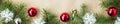 banner of Festive christmas border with red and silver balls on fir branches and snowflakes on rustic beige background Royalty Free Stock Photo