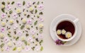 Banner. Flavored herbal tea in a white ceramic cup with a saucer. Floral pattern on a beige background. Flower tea concept. Tea