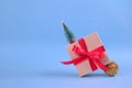 Banner with gift box with red bow and Christmas tree decorations on festive blue background with blurred bokeh and copyspace for Royalty Free Stock Photo