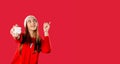 Banner. Girl holds a gift box and points up with a finger. Red background with space for your advertisment.