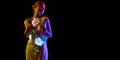 Banner. Half-length image of young sensual woman posing in neon light with illumination of flowers isolated on dark mode Royalty Free Stock Photo