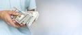 Banner with hand holding US one hundred dollar bills on a blue background. American money. Place for text Royalty Free Stock Photo