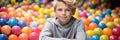 Banner Happy boy in fun childrens shopping center playing in a dry pool with colorful balls Royalty Free Stock Photo