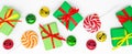 Banner Happy holidays: gifts with lollipops and red, green, golden bells on a white background. The concept of Christmas, sales, Royalty Free Stock Photo
