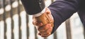 Banner and header panoramic horizontal - close up businessmen shaking hands and handing down business deals in urban center,