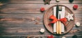 Banner holiday composition of Christmas dinner on wooden background. Top view of plate, utensil and festive decorations. New Year Royalty Free Stock Photo
