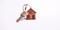 Banner with house keys with wooden keychain in house shape close-up isolated on white background for buying, renting an