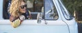 Banner image of young pretty woman traveler smile outside the window of her blue classic van vehicle. Traveler female people