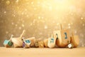 Banner of jewish holiday Hanukkah with wooden dreidels & x28;spinning top& x29; over glitter shiny background.