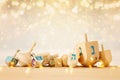 Banner of jewish holiday Hanukkah with wooden dreidels & x28;spinning top& x29; over glitter shiny background. Royalty Free Stock Photo