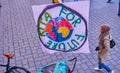 Banner of a kindergarten for fridays for future with a passing young woman of Muslim origin