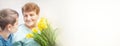 Banner of kindness to senior elderly woman. Boy giving a bunch of yellow flowers tulipan to grandmother. Royalty Free Stock Photo