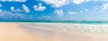 Banner of a large empty sandy beach and a clean warm sea and blue sky with few clouds as a symbol of an iconic summer holiday