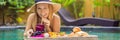 BANNER, LONG FORMAT Breakfast tray in swimming pool, floating breakfast in luxury hotel. Girl relaxing in the pool