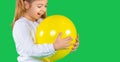 Banner- long format. Closeup photo of little girl, trying to bite a iluminating color balloon on a green background