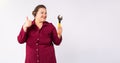 Banner, long format, grey background Female fat mechanic or a plumber, showing thumb up, working hard, holding a wrench