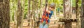 BANNER, LONG FORMAT Happy child in a helmet, healthy teenager school boy enjoying activity in a climbing adventure park Royalty Free Stock Photo