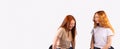 Banner,long format. The pastime of two red-haired girlfriends. Girls chat and smile on a gray background. Royalty Free Stock Photo