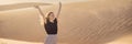 BANNER, LONG FORMAT Young beautiful woman traveling in the desert. Sandy dunes and blue sky on sunny summer day. Travel Royalty Free Stock Photo