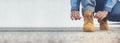 Banner man kneel down tie shoes lace on industry worker boots. Close up shot of man hands tied shoestring for his construction Royalty Free Stock Photo