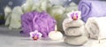 banner with massage stones, burning candles, rolled towels, flowers, abstract lights. Spa resort therapy composition Royalty Free Stock Photo