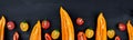 Banner of Mixed of half red and yellow pepper with a green branch near cherry tomato on a black backround Royalty Free Stock Photo
