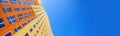 Banner multi-storey building with many glass windows standing against background of blue sky. Residential buildings