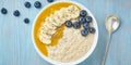 Banner with oatmeal, bananas, blueberries, chia seeds, mango jam on blue wooden background. Top view. Healthy breakfast