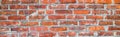 Banner with old shabby and wrecked red brick wall with grey cement mortar as background. Copy space