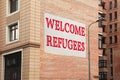 Banner with phrase WELCOME REFUGEES on building outdoors Royalty Free Stock Photo