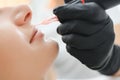 Banner Process woman applying permanent tattoo makeup on lips in beautician salon