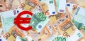 Banner with red felt Euro currency symbol on euro banknotes background. Financial concept.