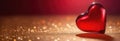 Banner with red glass heart on gold surface, festive background, warm blurred bokeh light. Valentine's Day Royalty Free Stock Photo