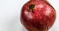 Banner. Red ripe pomegranate fruit against a white background. Anthers on ripe fruit up close. Rind outer skin of pomegranate.