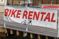 Banner that says Bike Rental attached to the railing of a wooden boardwalk