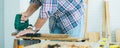 Banner and selective focus on male or carpenter hand using electrical drill to creating and making DIY wooden furniture for home Royalty Free Stock Photo