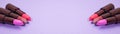 A banner of several tubes of lipstick on a purple background. Space for your text Royalty Free Stock Photo