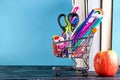 Banner of Shopping cart with school supply on a blue background with a books and an apple with copy space. Back to school Royalty Free Stock Photo