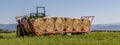 Banner size view of hay bales being lined up on a trailer to be transported off the field, Bientina, Italy