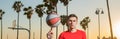 Banner of sports man hold basketball ball on Venice beach basketball court. Hand spinning basket ball. Balancing Royalty Free Stock Photo