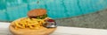 banner of tasty hamburger, appetizing french fries and ketchup. concept of relaxing and eating by the sea on a bright