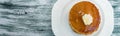 Banner of Top view of pancakes with butter and honey or maple syrup on white plate