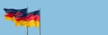 Banner with two national black red yellow flags of Germany at blue sky solid background with copy space, details, closeup. Concept