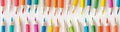A banner with two rows of colored pencils from the edges on a white background. The concept of children\'s creativity Royalty Free Stock Photo