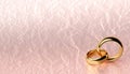 Banner of two wedding gold rings lie on each other with blank background and crumpled paper texture Royalty Free Stock Photo