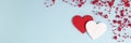 banner of Valentine's Day background. Two hearts with red confetti, beads with hearts on pastel blue colors Royalty Free Stock Photo